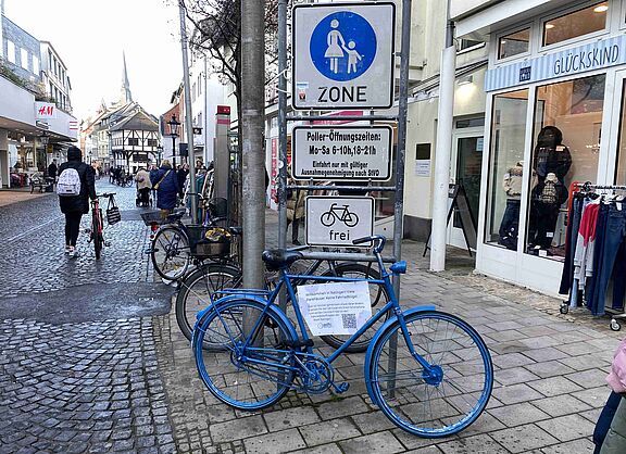 Blaues Fahrrad in als Hinweis auf fehlende Abstellbügel