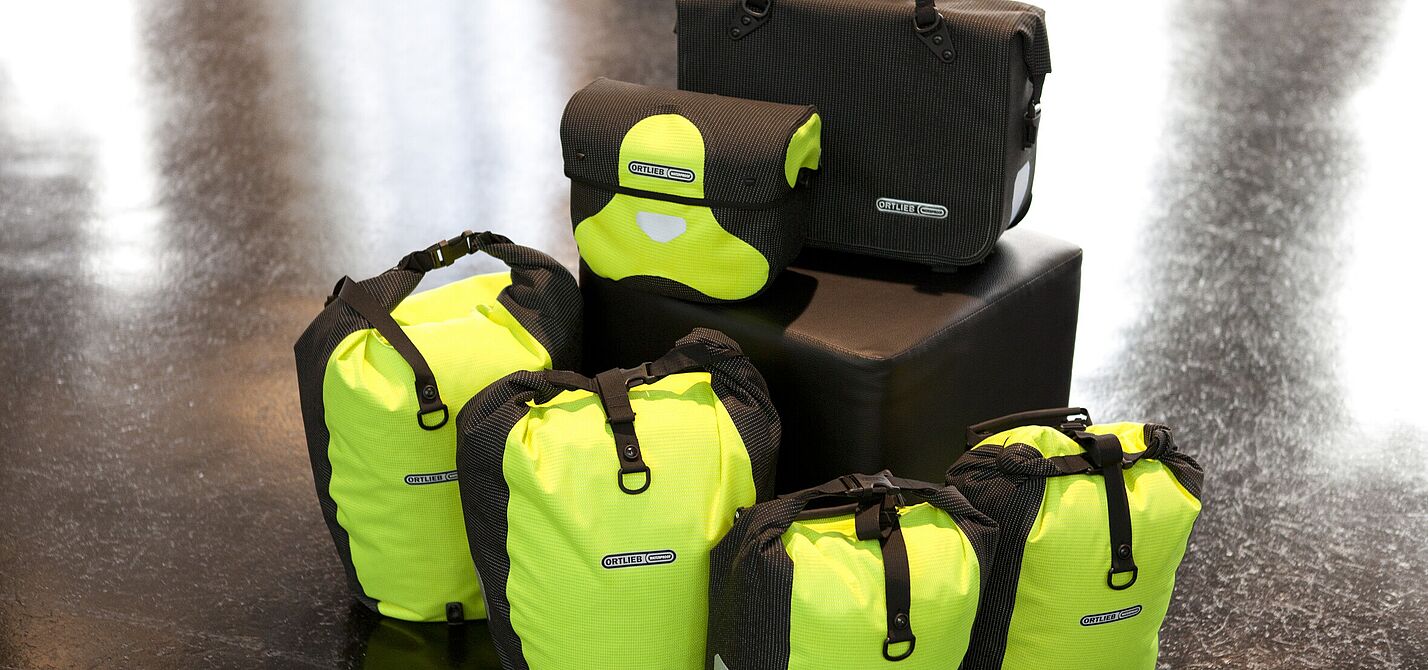 Komplett reflektierende Taschenset mit Back- und Frontrollern und Lenkertasche in gelb, Fahrradaktentasche in schwarz. Komplett reflektierende Taschenset mit Back- und Frontrollern und Lenkertasche in gelb, Fahrradaktentasche in schwarz.